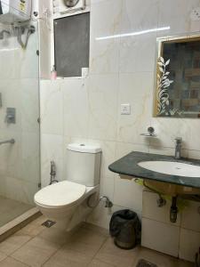 a bathroom with a toilet and a sink at The Origin Suites opposite Hyatt Dlf my pad Lucknow in Lucknow +24 photos