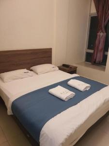 a large bed with two towels on top of it at JH Hotel in Singapore +75 photos