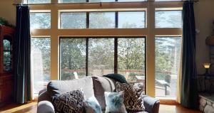 a living room with a couch in front of a large window at Emerald Oasis in Lake Arrowhead