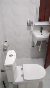 a white bathroom with a toilet and a sink at Hidden Gem KAG Kitengela in Stony Athi