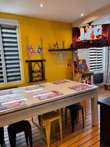 a table in a room with a yellow wall at ArCaDe RoOm Jacuzzi, Arcade, Billard, Ping Pong in Magenta