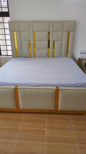 a bed in a room with a wooden floor at Hidden Gem KAG Kitengela in Stony Athi