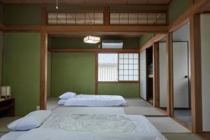 two beds in a room with green walls at Wan Kumano by WhyKumano in Nachikatsuura