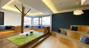 a living room with a tree in the middle of the room at Need a Nap Hostel Phrae in Phrae +163 photos