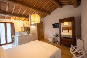 a bedroom with a white bed and a kitchen at La casina del borgo - Monolocale Nettuno in Perugia