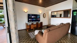 a living room with a couch and a flat screen tv at PK 35 in Apomaoro