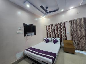 a bedroom with a bed and a tv and a chair at JBL Beach Resort Mandarmoni in Mandarmoni