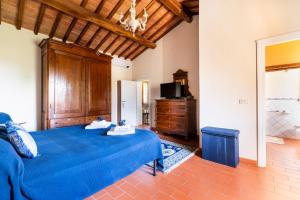 a bedroom with a blue bed and a tv at CASA LORY Poggio Murella in Poggio Murella