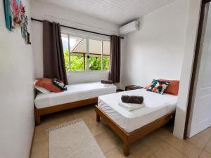 a bedroom with two beds and a window at PK 35 in Apomaoro
