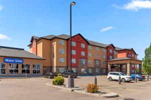 a large building with cars parked in a parking lot at Comfort Inn & Suites Red Deer - Highway 11 in Red Deer