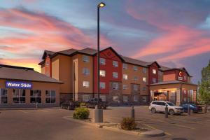 a building with cars parked in a parking lot at Comfort Inn & Suites Red Deer - Highway 11 in Red Deer