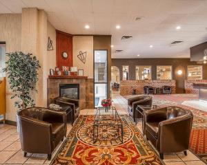 a lobby with chairs and a table and a fireplace at Quality Inn & Conference Centre Red Deer - 50th Avenue in Red Deer