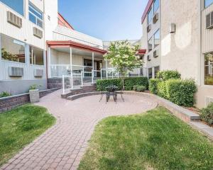 a patio with a picnic table in the courtyard of a building at Quality Inn & Conference Centre Red Deer - 50th Avenue in Red Deer