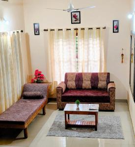 a living room with two couches and a coffee table at Coffee View Holiday Homes in Thirunelli