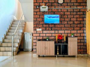 a brick wall with a clock on a wall at Coffee View Holiday Homes in Thirunelli