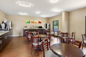 a restaurant with tables and chairs and a kitchen at Quality Inn Kinston Hwy 70 in Kinston