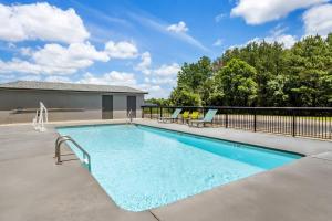 a swimming pool with two chairs next to a house at Quality Inn Battleboro - Rocky Mount in Battleboro