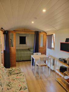 a living room with a table and a couch at roulotte en bois in Ranton