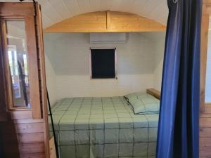 a small bedroom with a bed in a room at roulotte en bois in Ranton