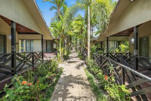 a walkway in front of a building with palm trees at Orator Hotel in Siusega