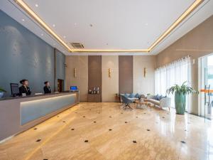 two men sitting at a reception desk in a lobby at Uniton Hotel Shenzhen in Shenzhen