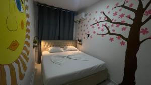 a bedroom with a bed with a tree painted on the wall at Vlora Backpackers Hostel & Bar LUNGOMARE in Vlorë +68 photos