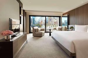 a bedroom with a large bed and a living room at Hotel Donland in Gwalior