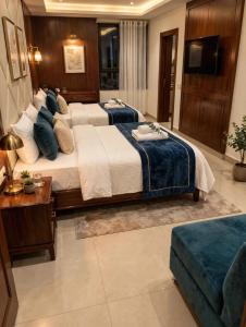 a large bedroom with two beds and a television at Hotel Donland in Gwalior