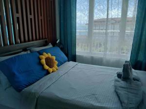 a teddy bear laying on a bed with a window at Spacious Studio unit with Balcony and Seaview in Punta Engaño +18 photos
