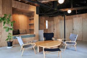 a room with a table and chairs and a bed at Nem Kumano by WhyKumano in Nachikatsuura