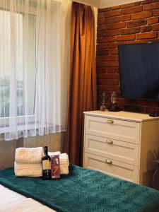 a bedroom with a bed with a dresser and a television at Jacuzzi Przemyska in Krakow