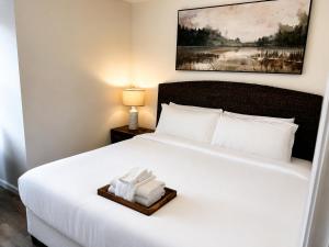 a hotel room with a bed with a tray of towels at The Riverwood Retreat in St. Charles