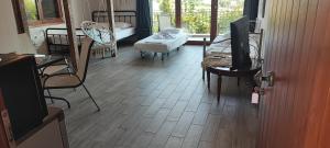 a living room with a tv and a wooden floor at Stone house with seaview in Nea Potidaea