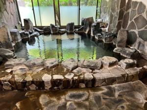 a pool of water in a stone wall at 旅館丸正 in Oguni