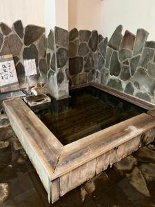 a large pool of water in front of a stone wall at 旅館丸正 in Oguni