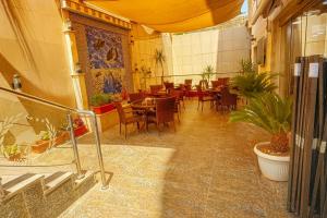 a restaurant with tables and chairs in a room at Aljamal Hotel in Amman