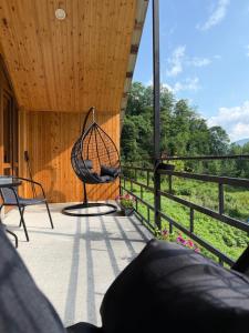 a swinging chair on a porch with a view at Guesthouse Riverside Bagiana in Roshka