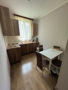 a kitchen with a table and chairs in a room at Guesthouse Riverside Bagiana in Roshka