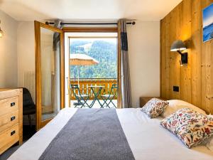 a bedroom with a bed and a view of a balcony at Hôtel Belalp in Châtel