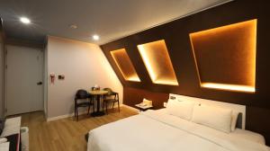 a hotel room with a bed and a small table at 수원행궁 넘버25 in Suwon