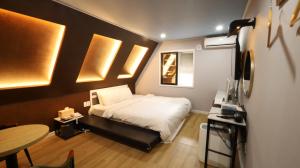 a small bedroom with a bed and a table at 수원행궁 넘버25 in Suwon
