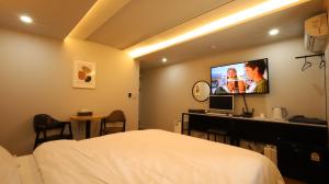 a bedroom with a bed and a tv on the wall at 수원행궁 넘버25 in Suwon