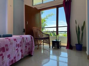 a bedroom with a pink bed and a window at Peace Abode Vista in Dibrugarh