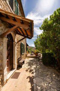 a walkway leading to a building with a wooden door at CASA LORY Poggio Murella in Poggio Murella