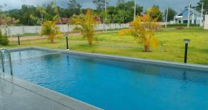 a large swimming pool in a yard with trees at Indigo Garden Villa by Somjai in Ban Tha Fat