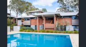 a house with a swimming pool in front of a house at Apartment 46 - Town Central - Close to Walktrails in Margaret River Town