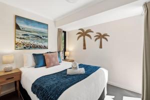 a bedroom with a bed and palm trees in it at Apartment 46 - Town Central - Close to Walktrails in Margaret River Town +16 photos