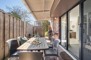 a patio with a wooden table and chairs at Apartment 46 - Town Central - Close to Walktrails in Margaret River Town