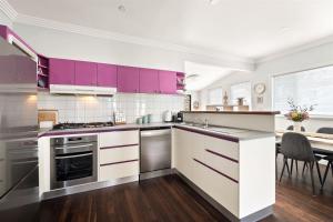 a kitchen with purple cabinets and a dining room at Elva Garden Cottage - Dog Friendly - Town Central in Margaret River Town