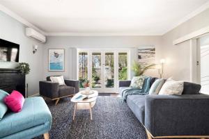 a living room with two blue couches and a table at Elva Garden Cottage - Dog Friendly - Town Central in Margaret River Town